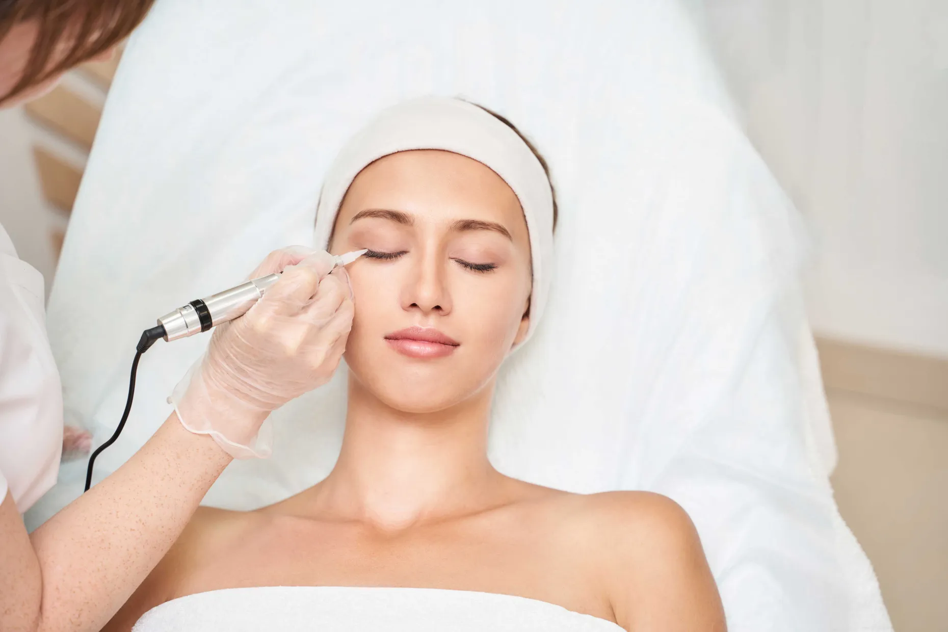 Permanent makeup artist carefully performing a brow service